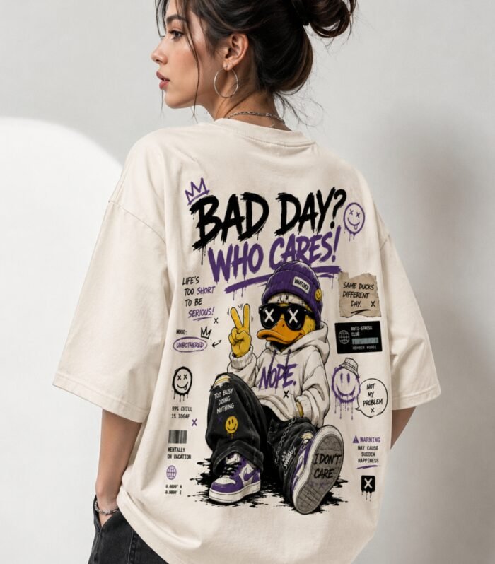 Woman wearing LURI Bad Day Who Cares graphic oversized t-shirt back print – streetwear duck character with attitude text on cream Supima cotton